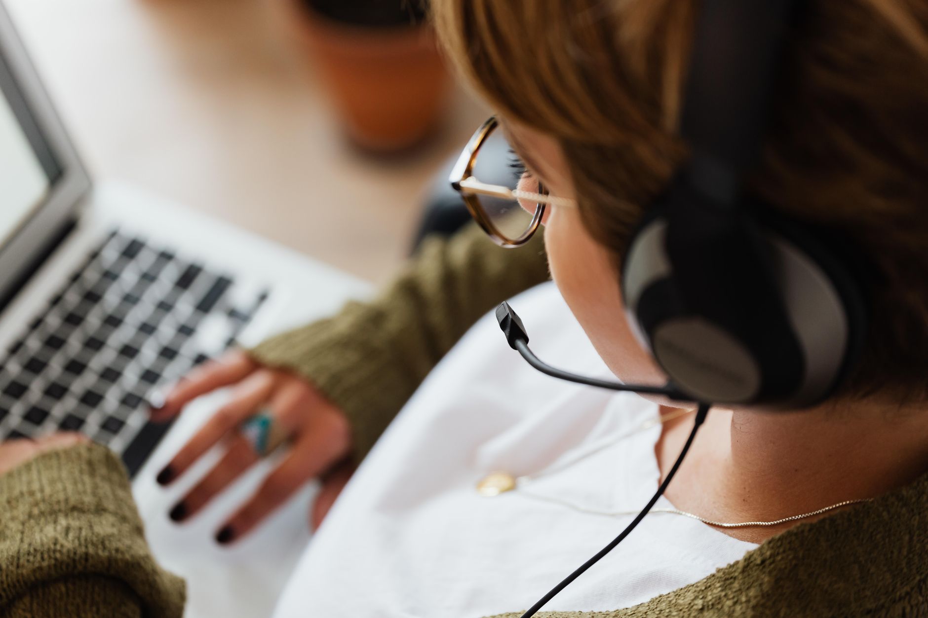 A woman typing with headphones on