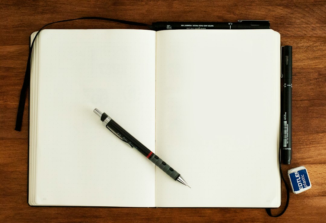 A pen resting on a blank notebook