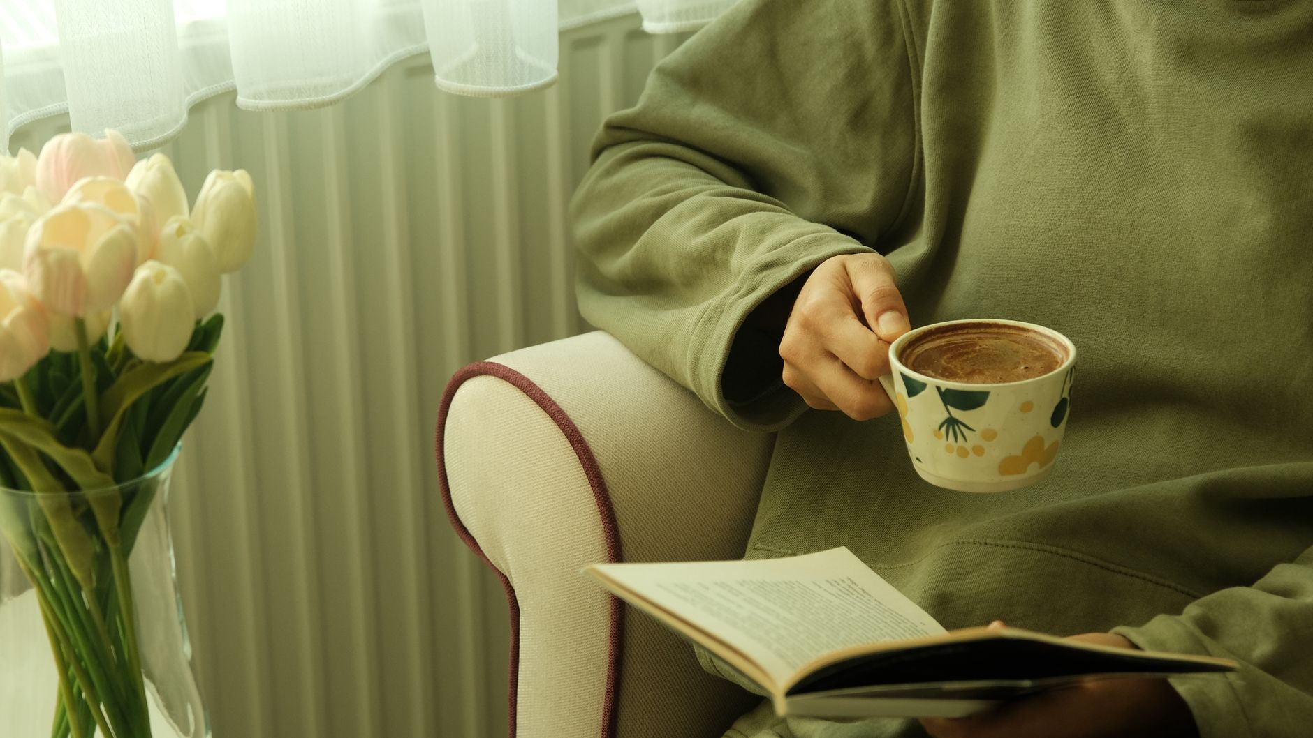 A person relaxing with a coffee and a book