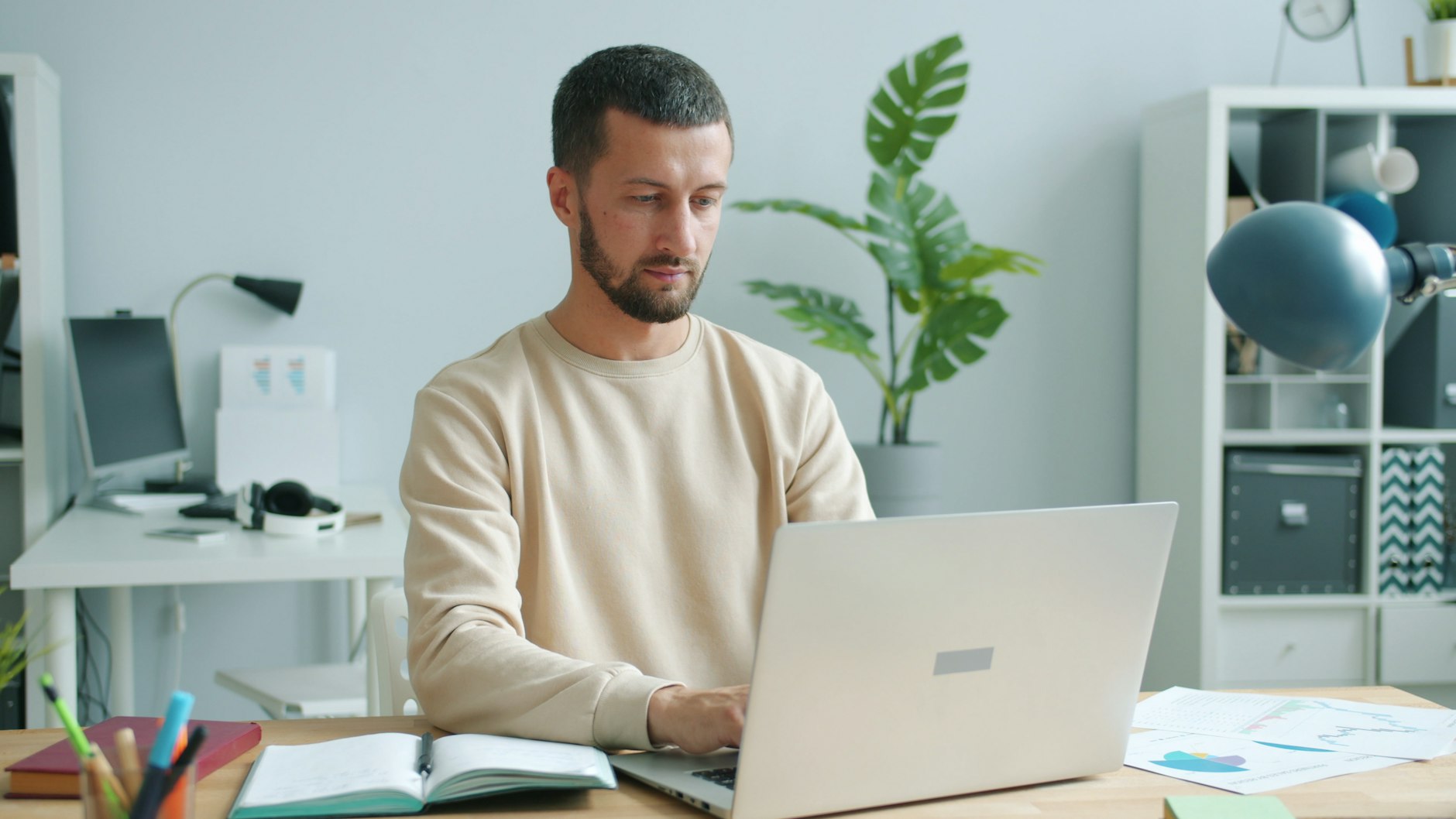 A freelancer working on a laptop in a bright home office