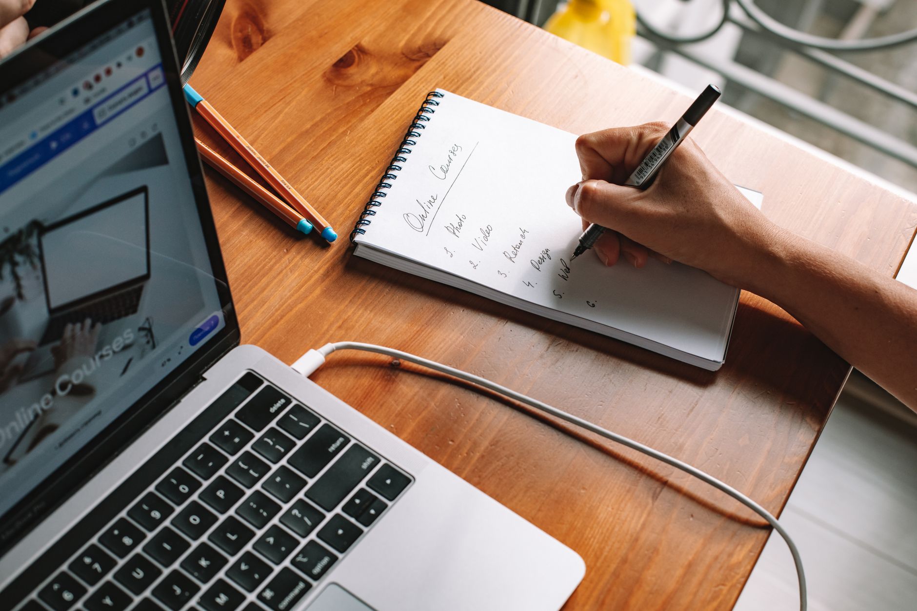 A woman taking notes during an online course