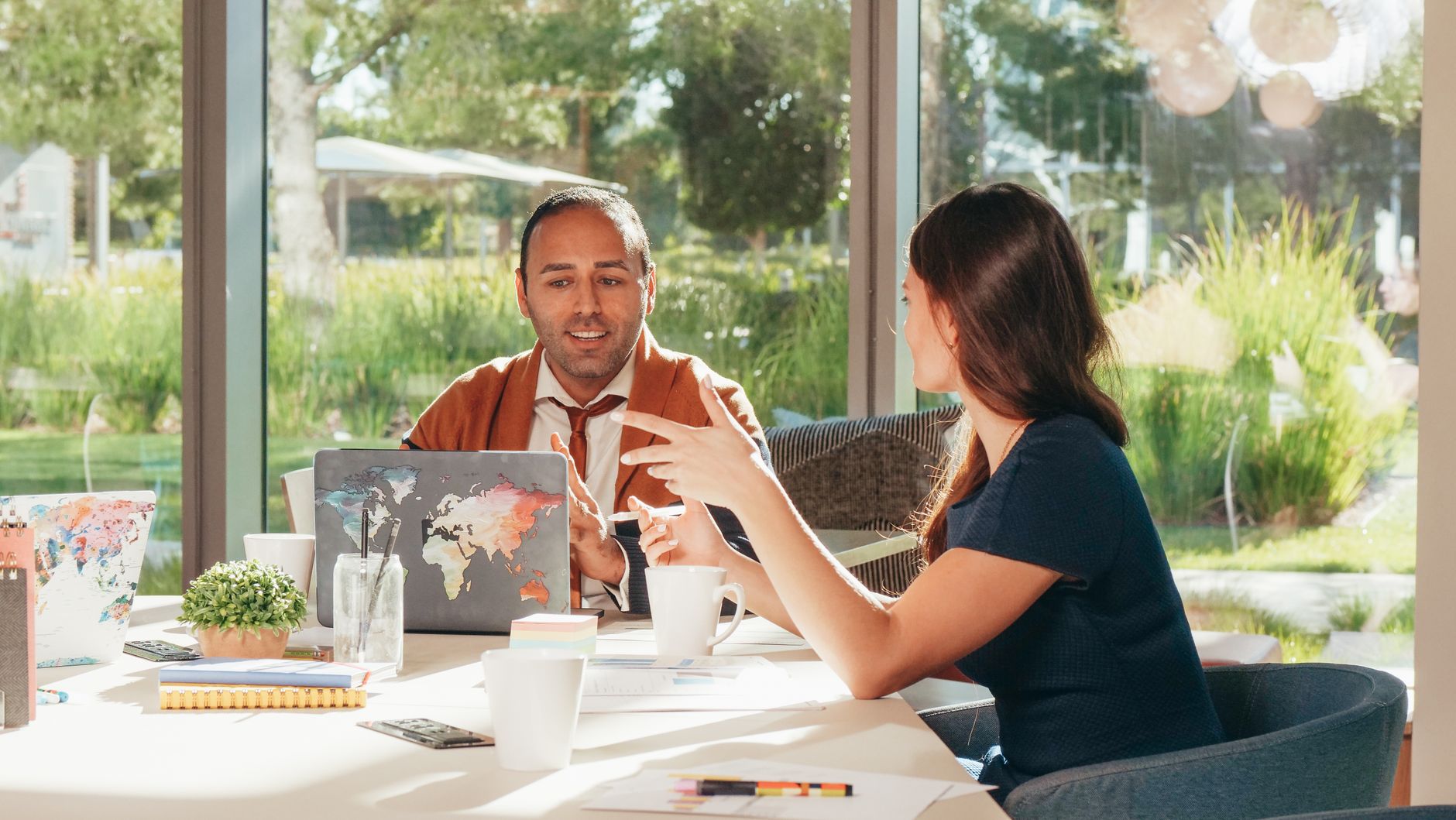 Two people discussing a strategy over a laptop