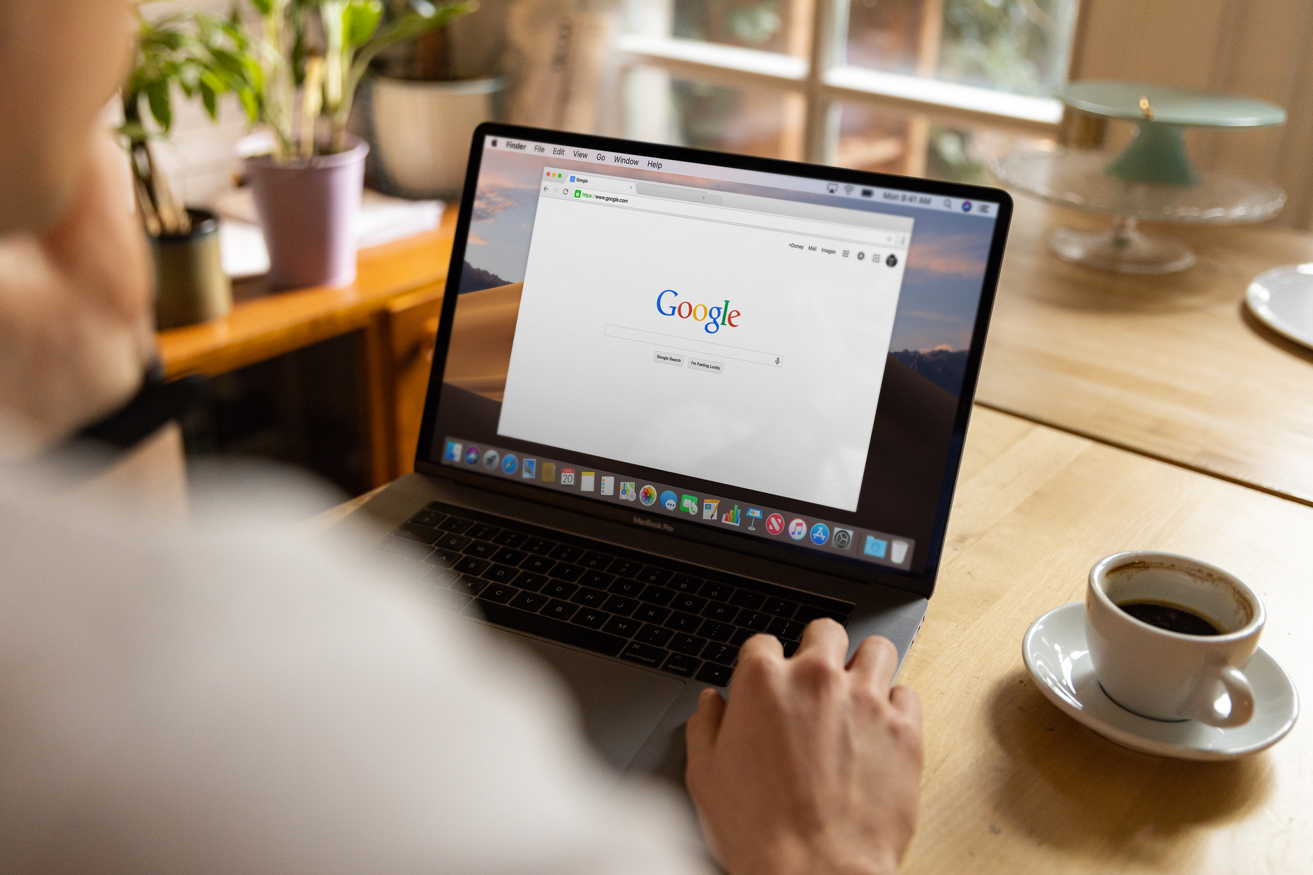A person typing a query into a search engine on a laptop