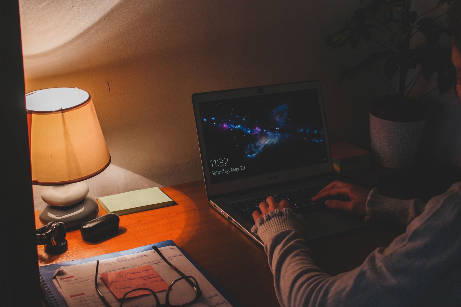 A person working late at a laptop under a lamp