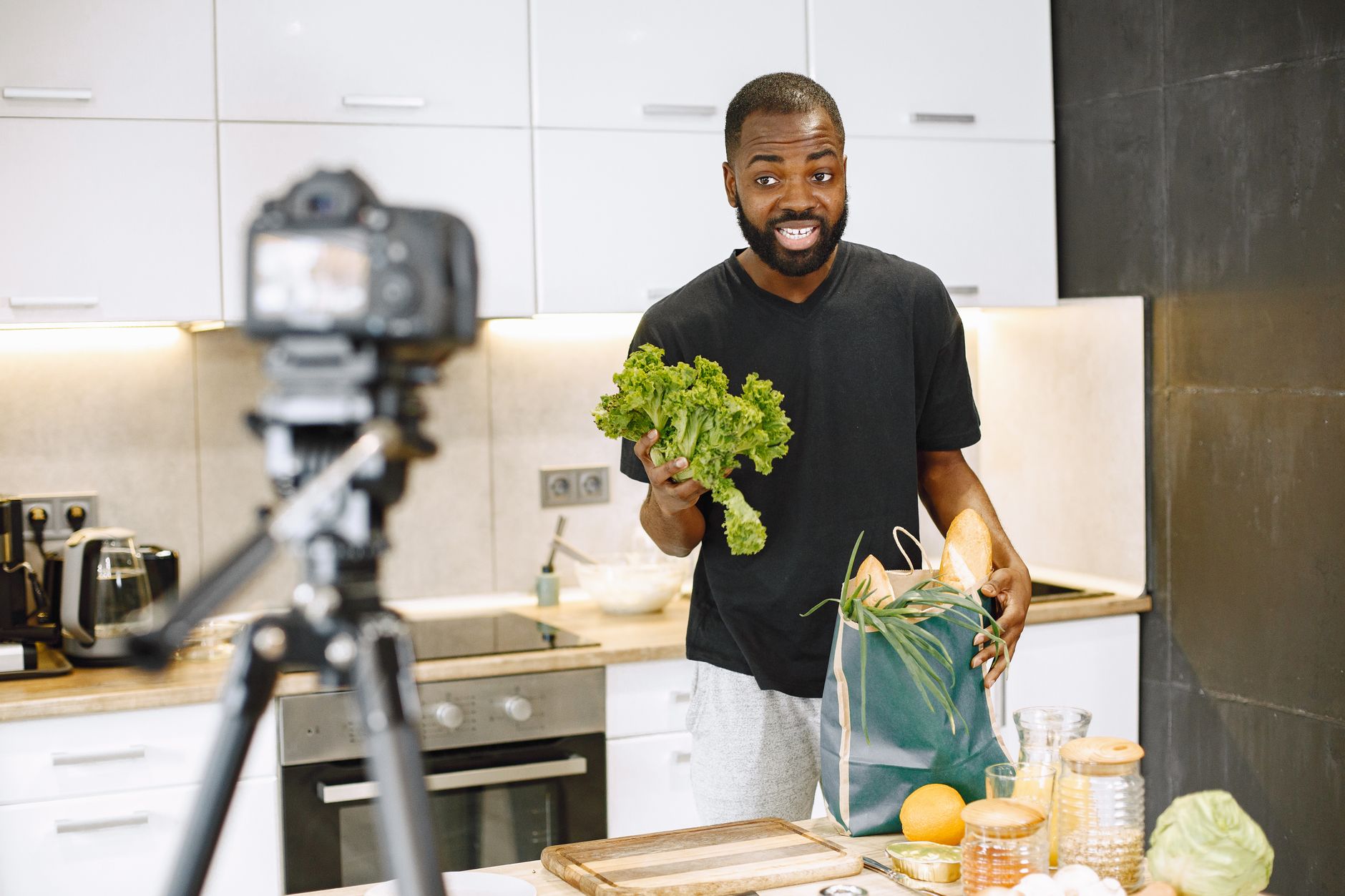 A man filming a cooking video in his kitchen