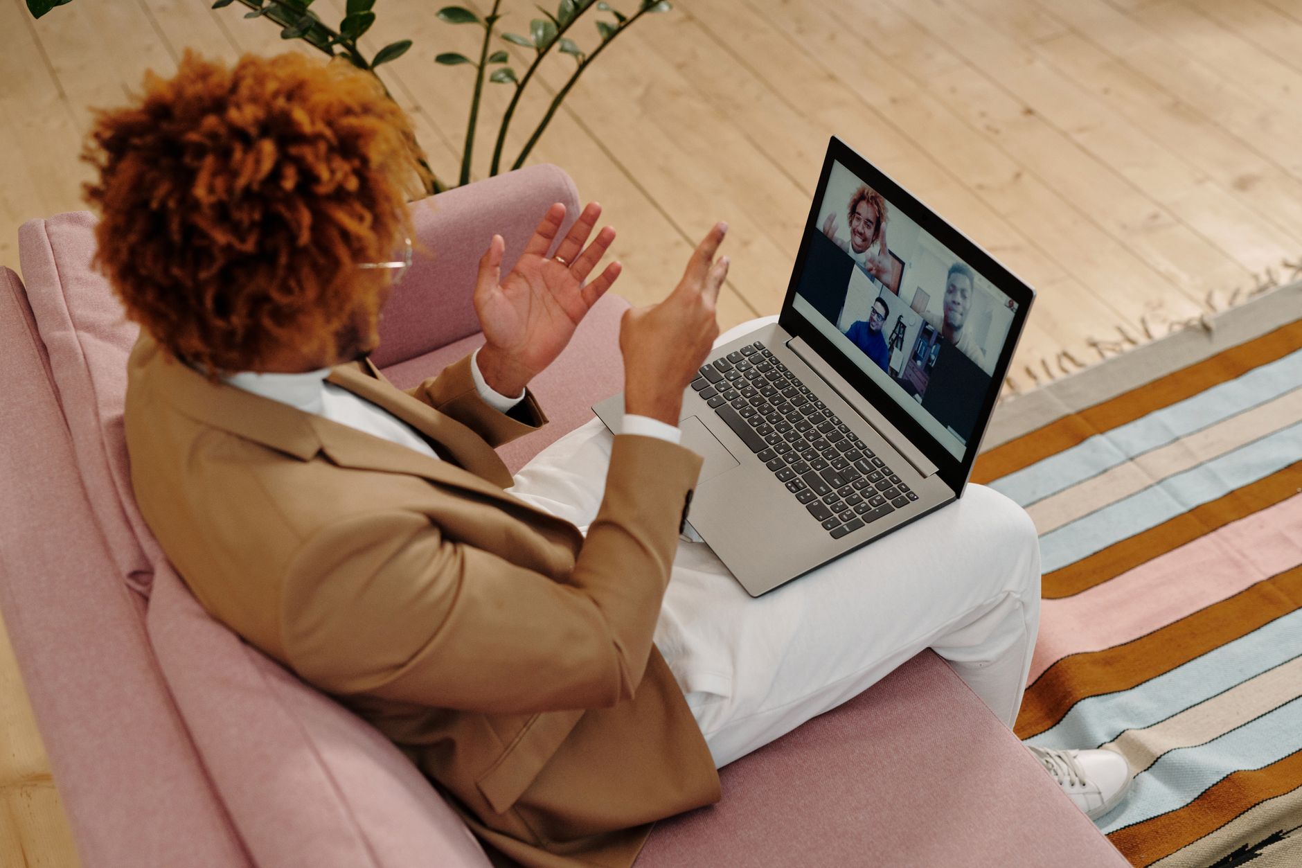 A man in a suit on a video call from his sofa
