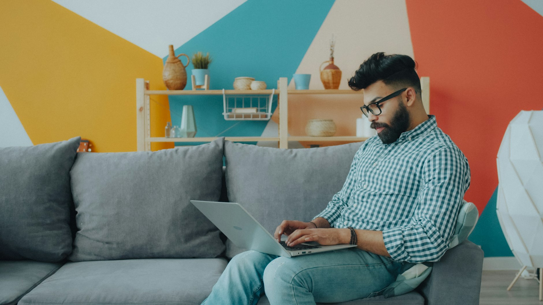 A man working on a laptop from his couch at home