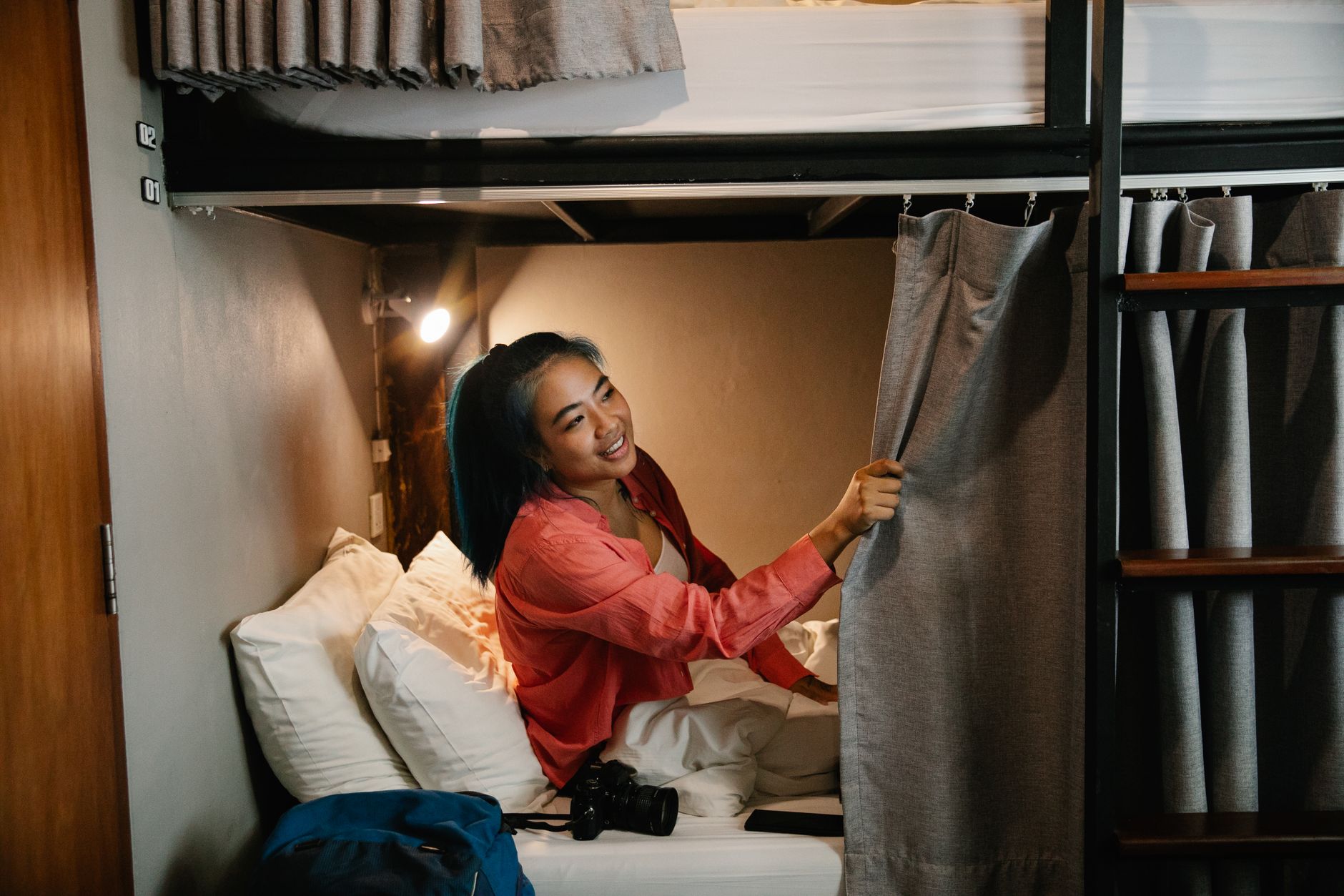 A traveler writing on a laptop in a hostel